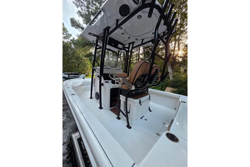 Slide: The Image of 2024 Sea Pro 250 Bay boat with center console and seating, surrounded by trees. - 9