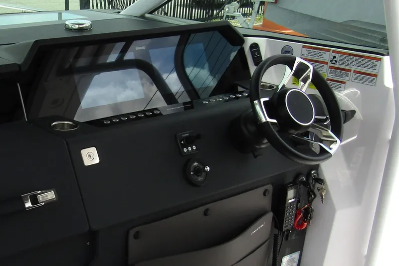 Slide: The Image of 2024 Axopar 37 Sun Top helm with modern steering wheel and control panel. - 15