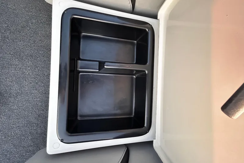 Slide: The Image of 2024 Triton 179 TrX storage compartment with black interior and gray exterior. - 10