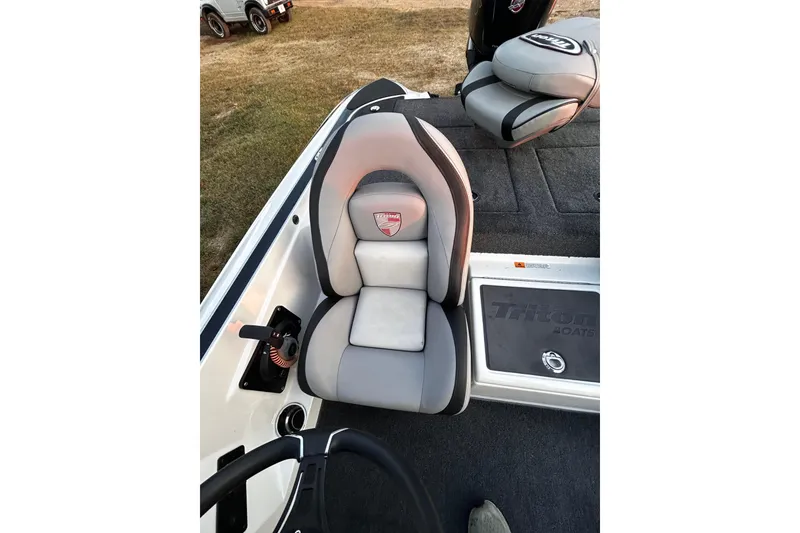 Slide: The Image of 2024 Triton 179 TrX boat interior with gray seating and steering wheel. - 12