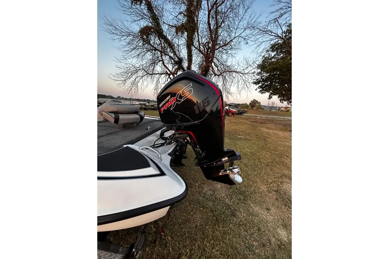 Slide: The Image of 2024 Triton 179 TrX boat with Mercury Pro XS engine, parked on grass near a lake. - 26