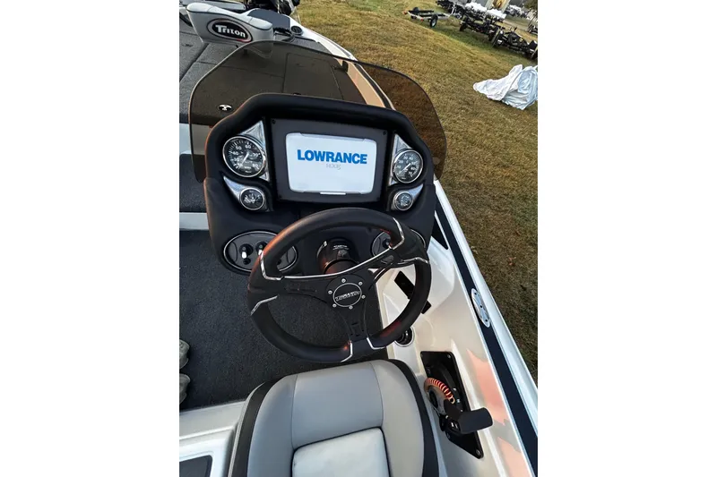 Slide: The Image of 2024 Triton 179 TrX boat dashboard with Lowrance display and steering wheel. - 4