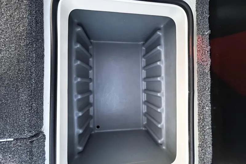 Slide: The Image of 2024 Triton 179 TrX storage compartment with gray interior and carpeted edges. - 9