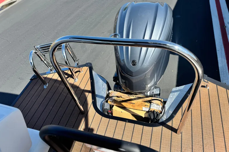 Slide: The Image of 2025 Manitou EXPLORE 26 boat with outboard motor and deck railing. - 19