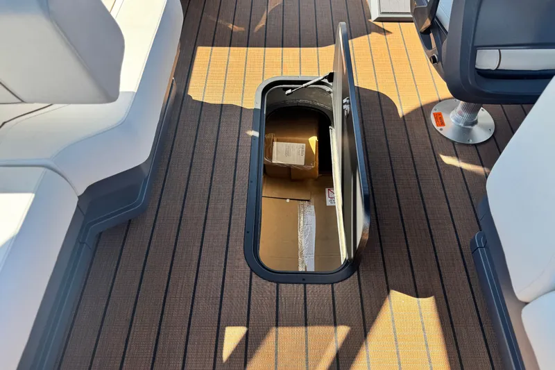 Slide: The Image of Manitou EXPLORE 26 boat interior with open storage compartment, 2025 model. - 21