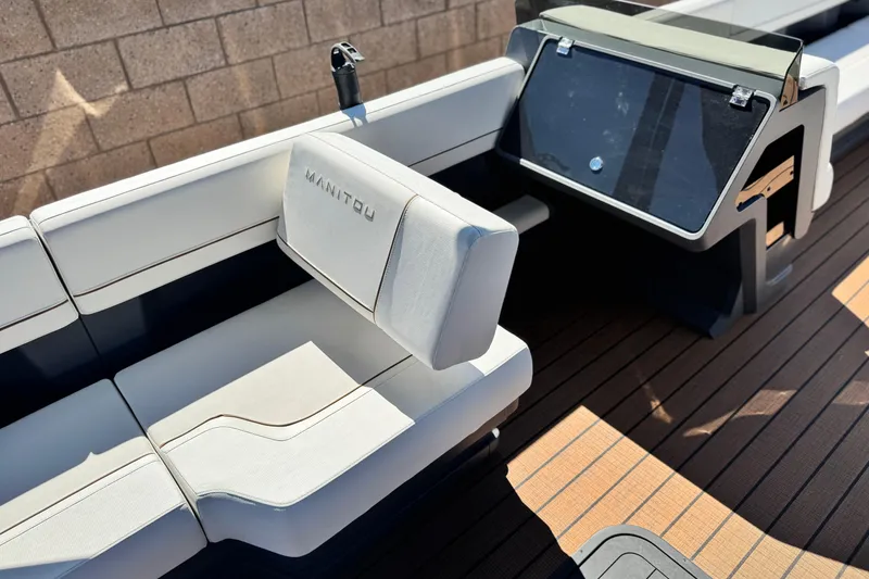 Slide: The Image of 2025 Manitou EXPLORE 26 boat interior with sleek seating and modern dashboard design. - 23