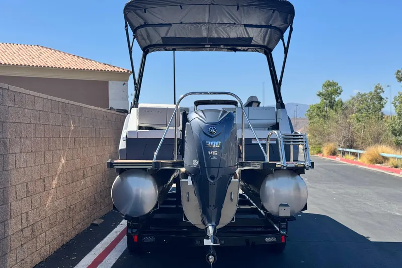 Slide: The Image of 2025 Manitou EXPLORE 26 pontoon boat with Yamaha V6 engine, parked outdoors. - 5