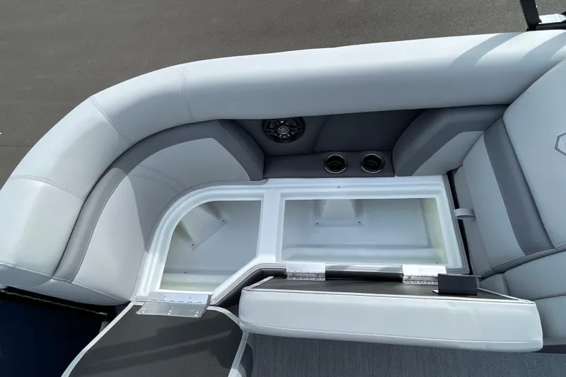 Slide: The Image of 2026 Godfrey Monaco 235 SB boat interior with open storage compartment and cup holders. - 11