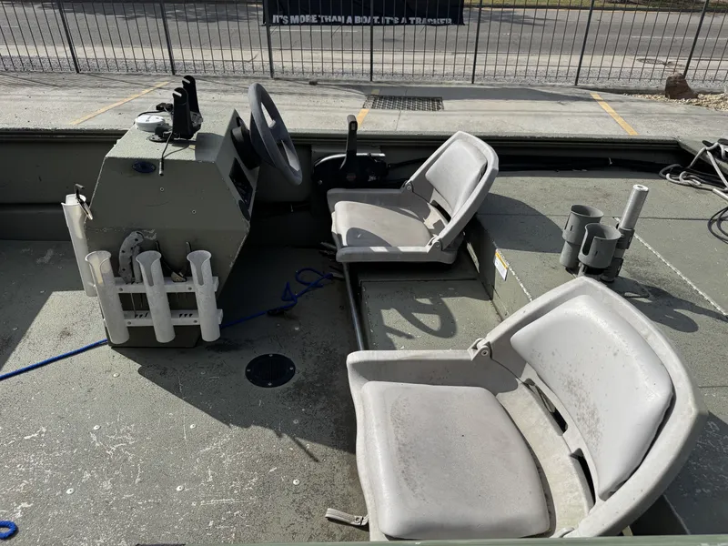 Slide: The Image of 2009 Lowe R1655SC boat interior with steering wheel, seats, and rod holders. - 14