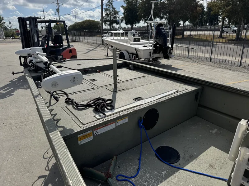 Slide: The Image of 2009 Lowe R1655SC boat with trolling motor, parked near forklift and trailer. - 15