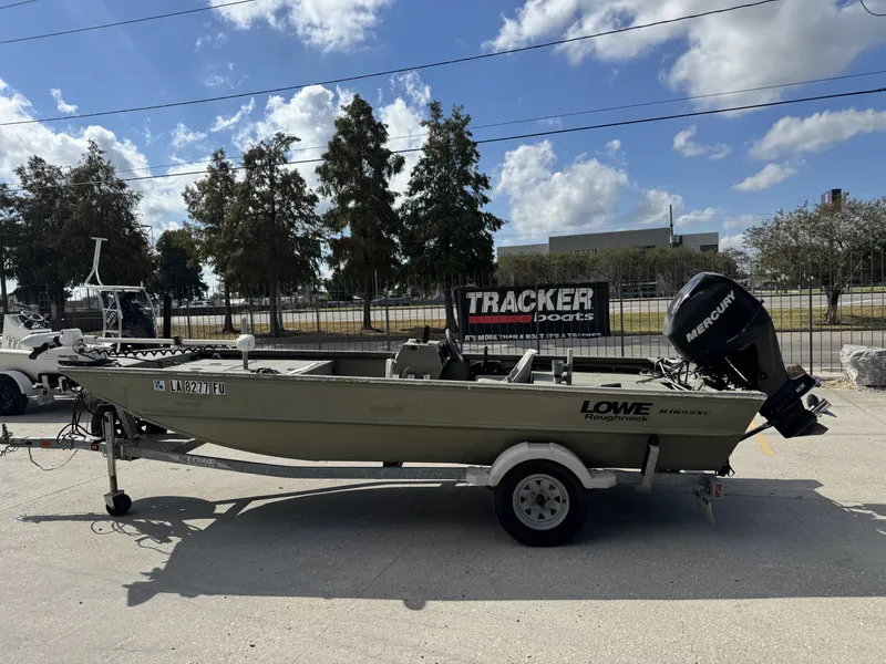 Slide: The Image of 2009 Lowe R1655SC boat on trailer with Mercury outboard motor, parked outdoors. - 9