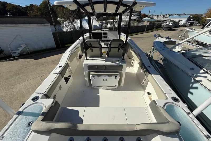 Slide: The Image of 2026 Key West 263 FS boat interior with seating, console, and storage, docked outdoors. - 15
