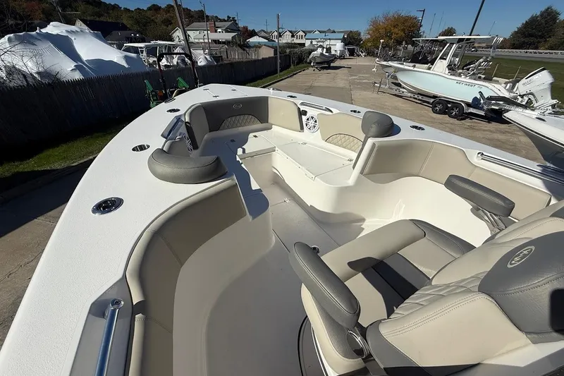 Slide: The Image of 2026 Key West 263 FS boat interior with seating and steering, docked outdoors. - 18