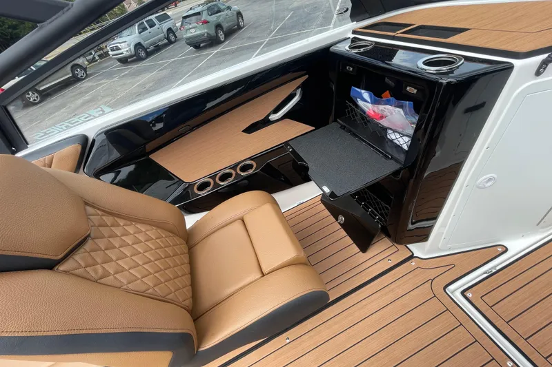 Slide: The Image of 2026 Yamaha 222SE boat interior with tan leather seating and sleek black storage compartments. - 20