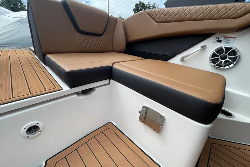 Slide: The Image of 2026 Yamaha 222SE boat interior with tan and black seating, wood-style flooring, and speaker. - 21