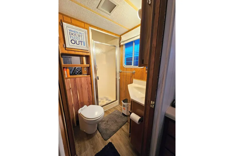 Slide: The Image of 1985 Sumerset 14x60 houseboat bathroom with shower, toilet, and wooden decor. - 15