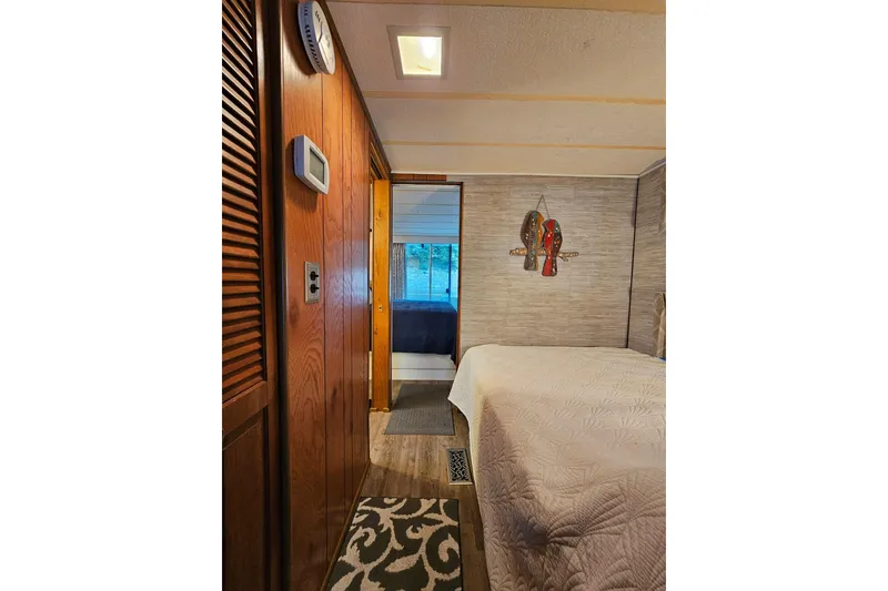 Slide: The Image of Interior of 1985 Sumerset 14x60 houseboat bedroom with wooden paneling and decorative wall art. - 17