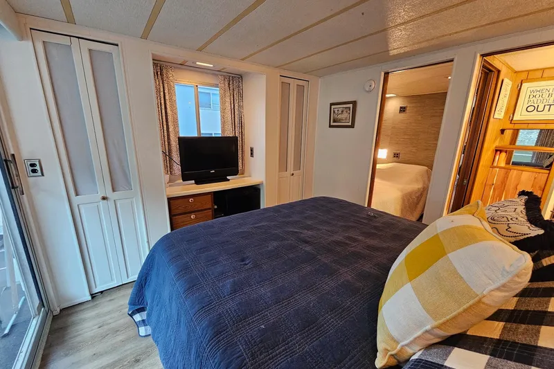 Slide: The Image of Bedroom interior of 1985 Sumerset 14x60 houseboat with cozy decor and TV. - 24