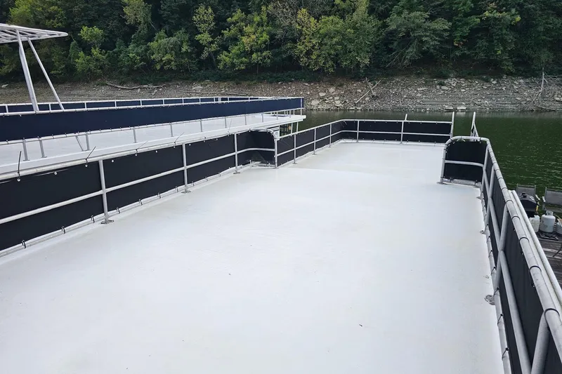 Slide: The Image of Rooftop deck of a 1985 Sumerset 14x60 houseboat, surrounded by lush greenery. - 32