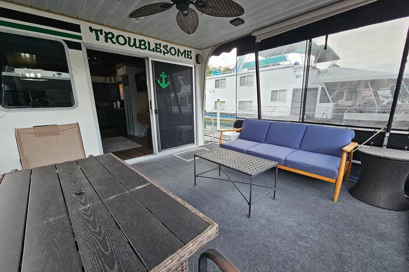 Slide: The Image of Houseboat interior with seating area, table, and decor on a 1985 Sumerset 14x60 model. - 4