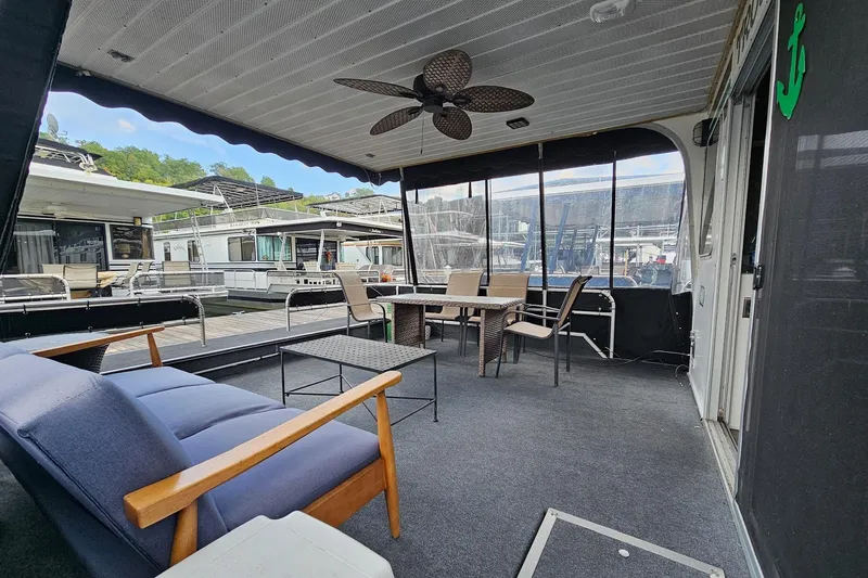 Slide: The Image of 1985 Sumerset 14x60 houseboat interior with seating area and marina view. - 5