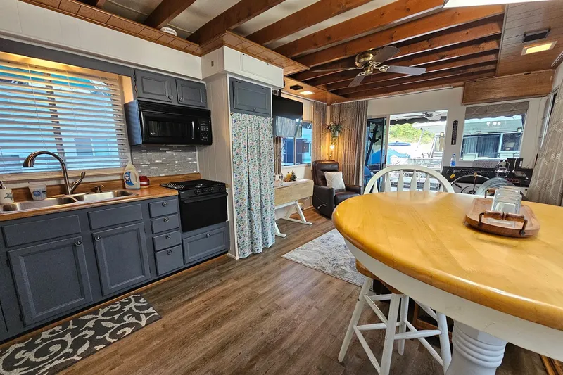 Slide: The Image of Interior of a 1985 Sumerset 14x60 houseboat with modern kitchen and dining area. - 9