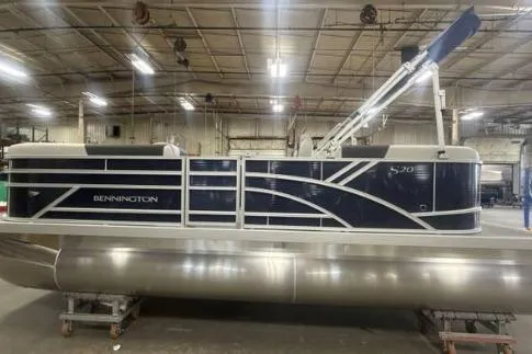 Slide: The Image of 2026 Bennington SSR pontoon boat in a warehouse setting. - 1