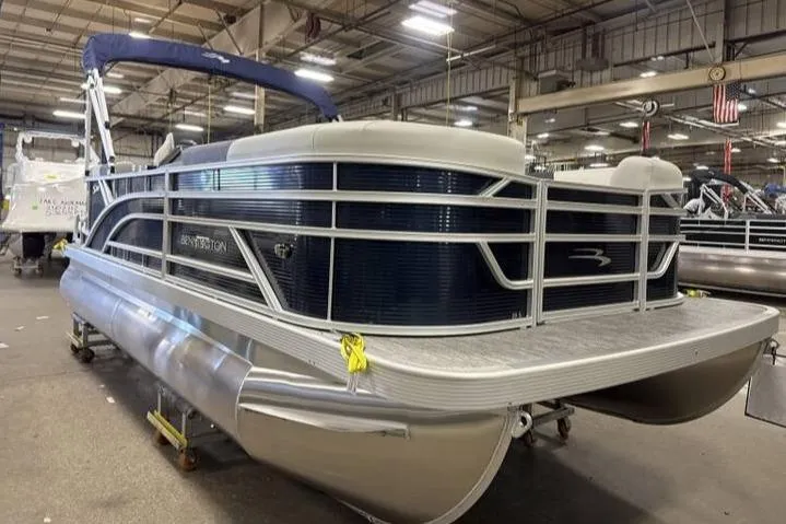 Slide: The Image of 2026 Bennington SSR pontoon boat in a warehouse setting, showcasing sleek design and modern features. - 2