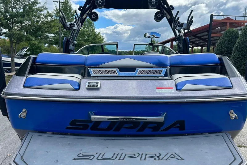 Slide: The Image of 2014 Supra SA 450 boat with blue seating and sleek design, parked outdoors. - 10