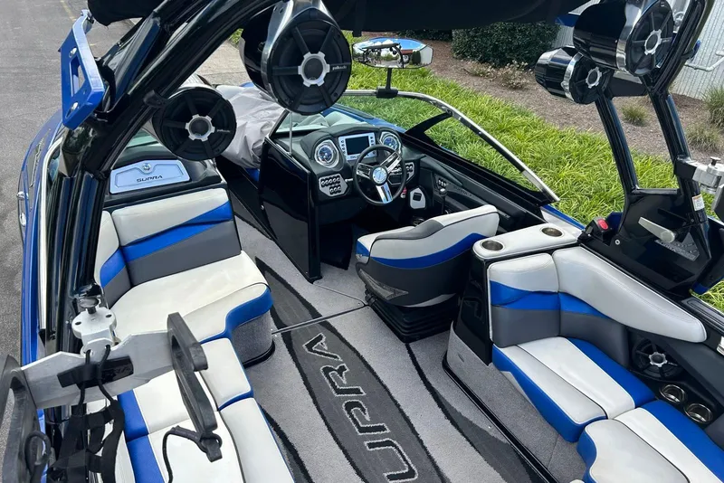 Slide: The Image of 2014 Supra SA 450 boat interior with blue and white seating, advanced dashboard, and speakers. - 11