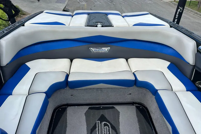 Slide: The Image of 2014 Supra SA 450 boat interior with blue and white cushioned seating. - 15