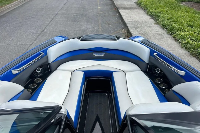 Slide: The Image of 2014 Supra SA 450 boat interior with blue and white seating, cup holders, and speakers. - 16