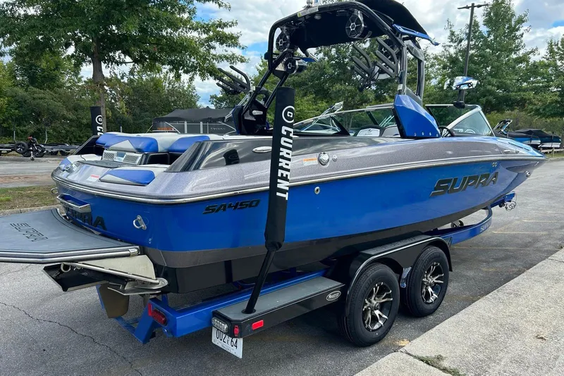 Slide: The Image of Blue 2014 Supra SA 450 boat on trailer, parked outdoors. - 2