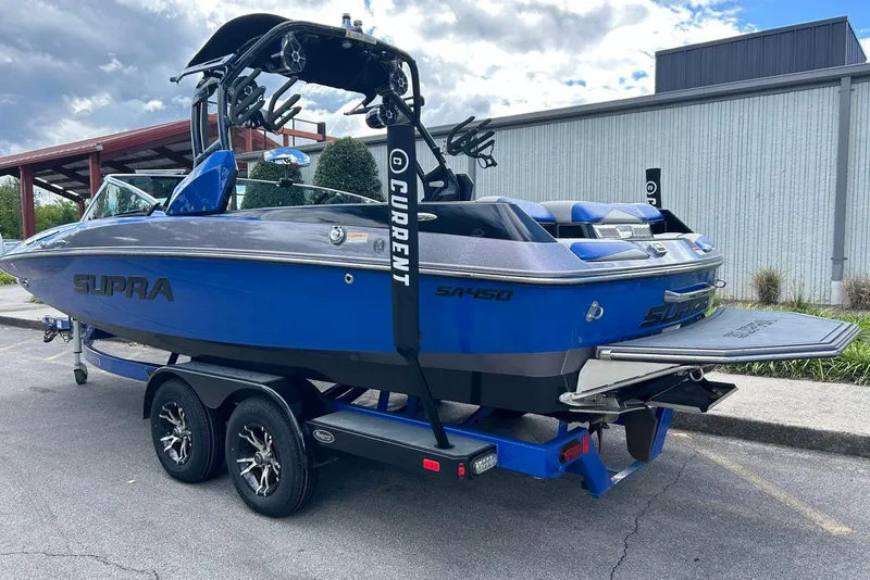 Slide: The Image of 2014 Supra SA 450 boat on trailer, blue and gray design, parked outdoors. - 8