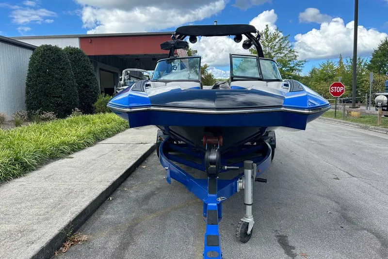 Slide: The Image of 2014 Supra SA 450 boat on trailer, parked outdoors near a building and greenery. - 9