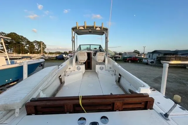 Slide: The Image of 1989 Hydra-Sports 2500WA boat docked, showcasing spacious deck and seating under clear sky. - 10