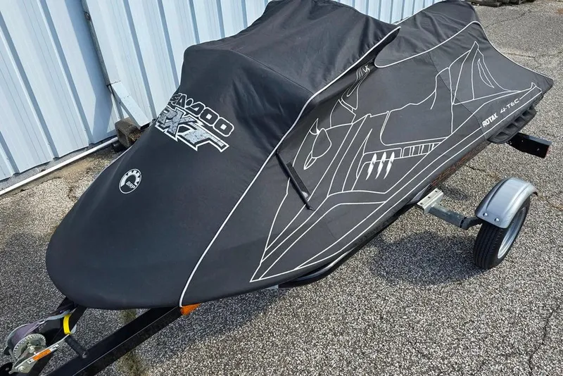 Slide: The Image of 2009 Sea-Doo RXT 255 jet ski covered on trailer, parked on pavement. - 11