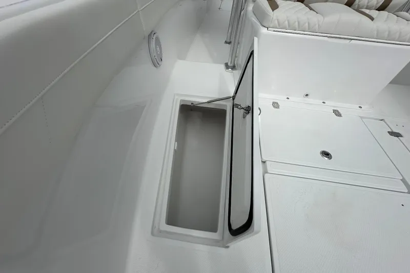 Slide: The Image of 2026 Bluewater 2850 boat interior with open storage compartment and cushioned seating. - 12