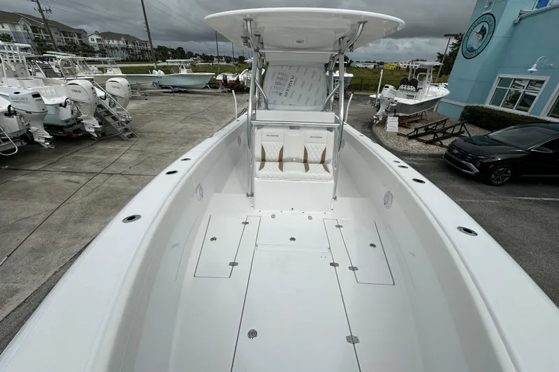 Slide: The Image of 2026 Bluewater 2850 boat with spacious deck, parked at a marina under cloudy skies. - 13