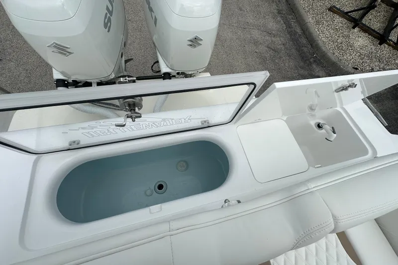 Slide: The Image of 2026 Bluewater 2850 boat with Suzuki engines, featuring a livewell and sink station. - 23