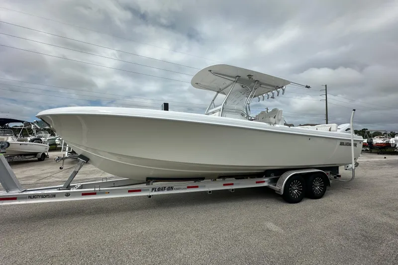Slide: The Image of 2026 Bluewater 2850 boat on trailer under cloudy sky. - 5