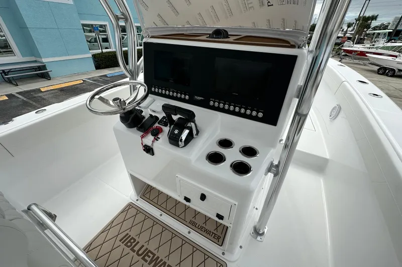 Slide: The Image of 2026 Bluewater 2850 boat console with steering wheel, controls, and cup holders. - 6