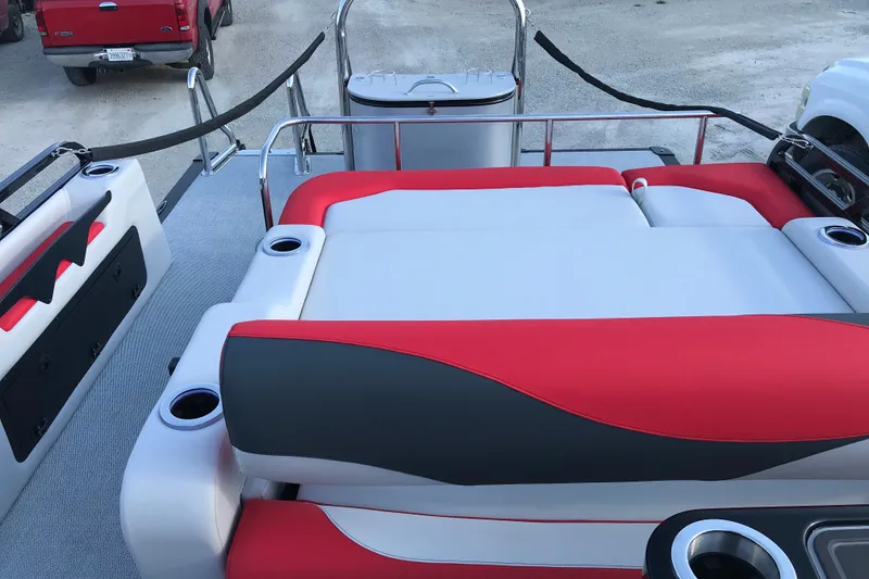 Slide: The Image of 2026 Avalon LSZ Entertainer boat interior with red and gray seating, cup holders, and steering console. - 17