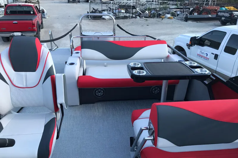 Slide: The Image of 2026 Avalon LSZ Entertainer boat interior with red and gray seating, cup holders, and railing. - 18