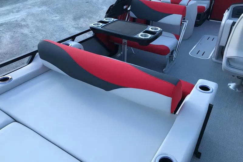Slide: The Image of 2026 Avalon LSZ Entertainer boat interior with red and gray seating and cup holders. - 21