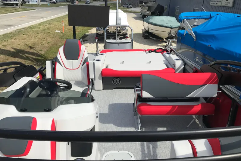 Slide: The Image of 2026 Avalon LSZ Entertainer boat interior with red and gray seating, steering console, and table. - 5