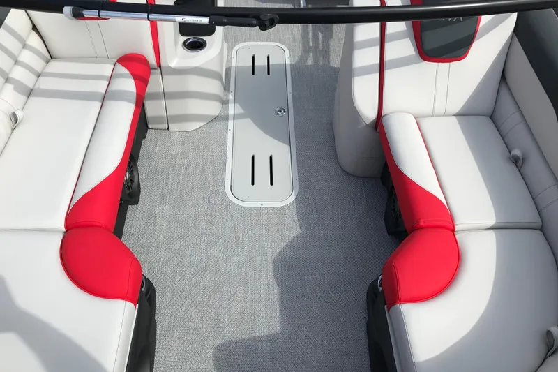 Slide: The Image of 2026 Avalon LSZ Entertainer boat with red and gray seating, parked outdoors. - 6
