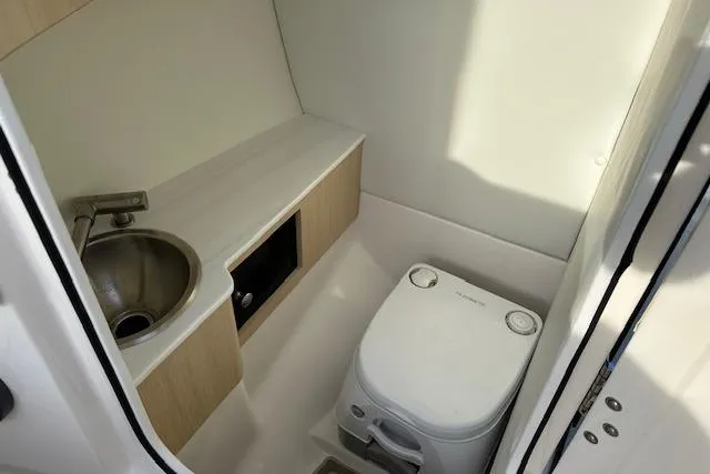 Slide: The Image of Compact bathroom in 2026 Regal LS6 boat with sink and portable toilet. - 13