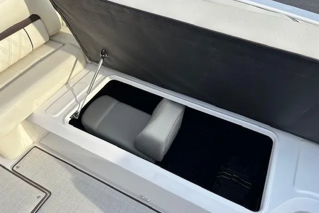 Slide: The Image of 2026 Regal LS6 boat storage compartment with cushioned seating and hydraulic lift. - 14