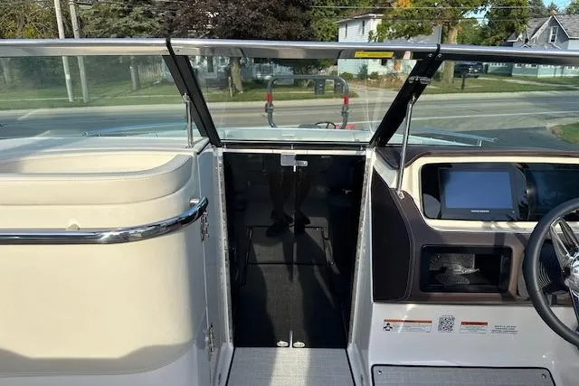 Slide: The Image of 2026 Regal LS6 boat interior with steering wheel and windshield, parked near residential area. - 19